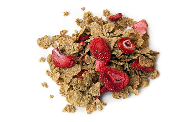 Cornflakes mixed with freeze-dried strawberry pieces.