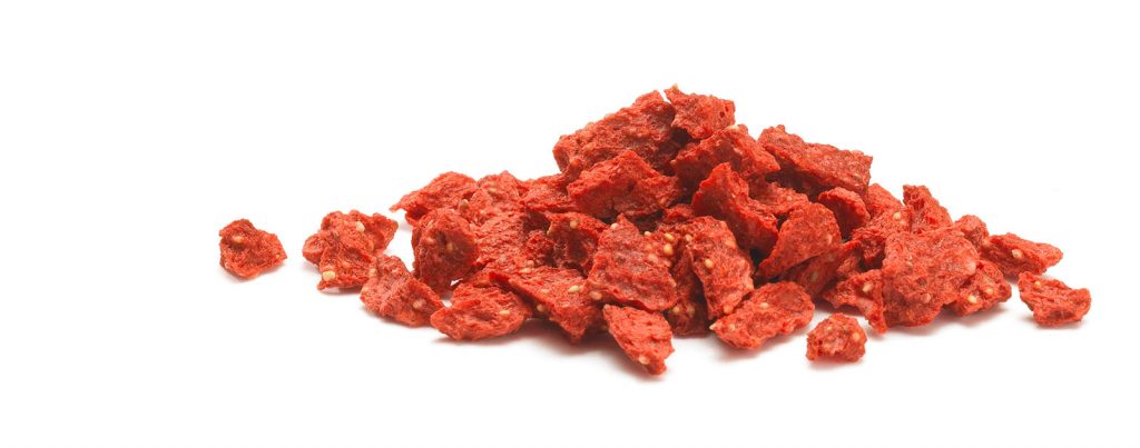 A pile of crunchy-looking freeze-dried strawberry pieces.