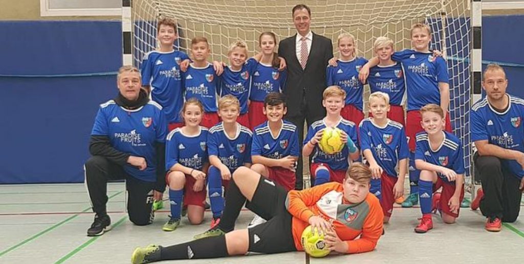 Neue Trikots für D-Jugend-Kicker Kurt Jahncke, Geschäftsführer von Paradise Fruits, mit einer U13-Fußballmannschaft.