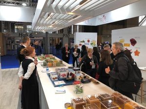 Paradise Fruits employees talking to customers during a trade show exhibition.