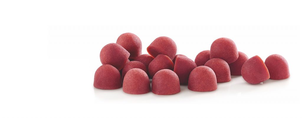 Un puñado de gomas de frutas rojas en forma de cúpula.