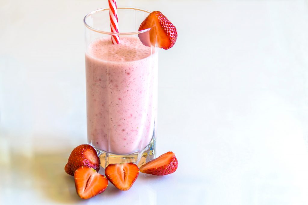 Delicious smoothie with strawberries and straw.