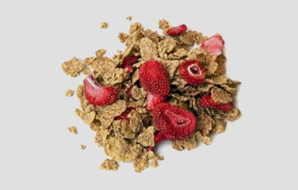 Cereales mezclados con trozos de fresa liofilizada.