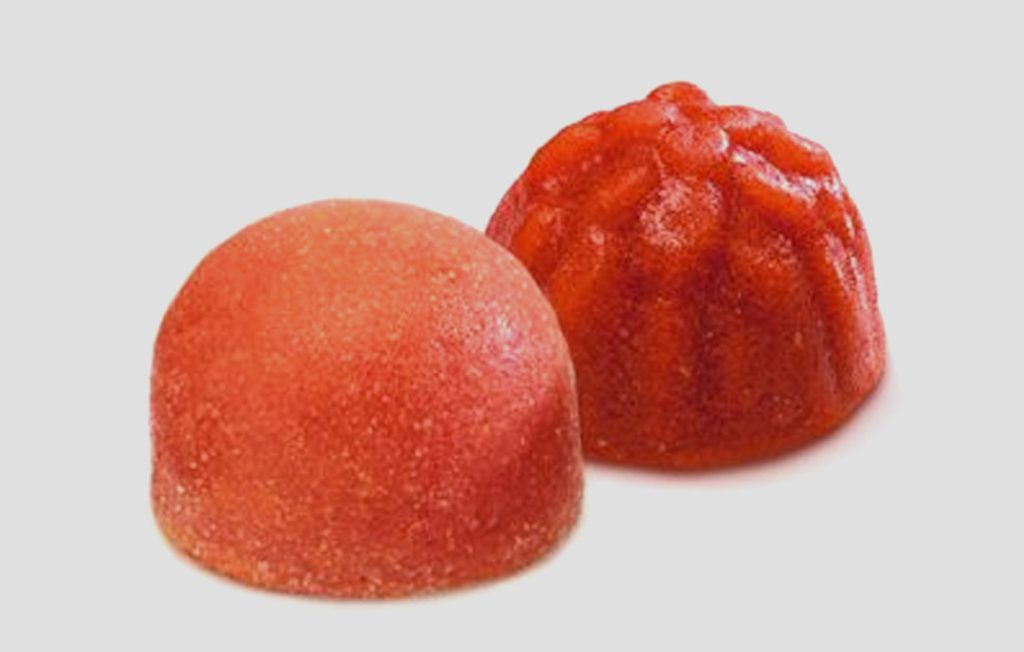 Innovación en la industria alimentaria Dos gomas de fruta rojas en forma de cúpula.