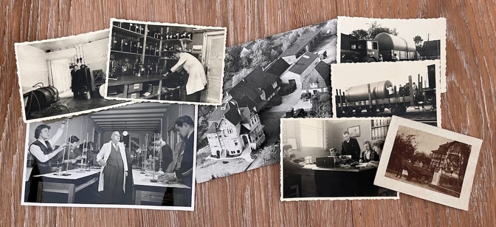 Varias fotografías antiguas sobre una mesa que muestran la empresa Paradise Fruits y el lugar de producción a lo largo de los años.