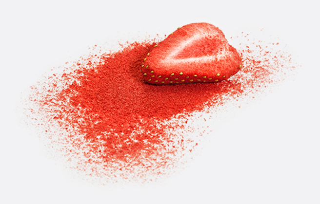 A slice of strawberry in a mound of red fruit powder.